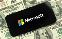 microsoft logo on smartphone 100 bills in backgroud